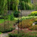 Установив кованую садовую арку, вы сможете превратить приусадебный участок в дворцовый парк,